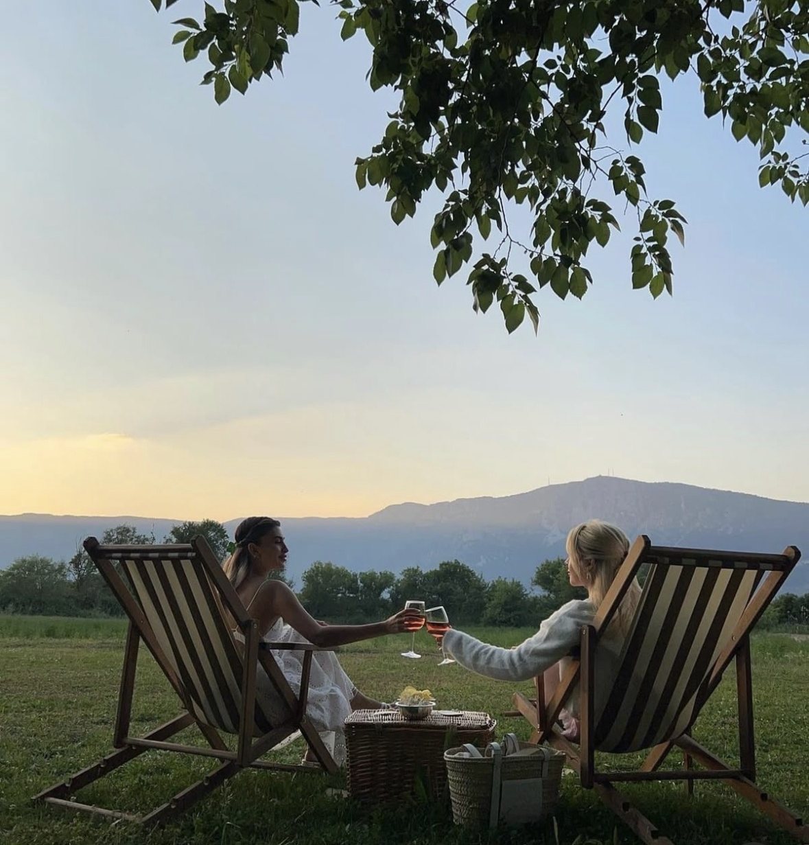 Due amiche brindano al tramonto tra le colline